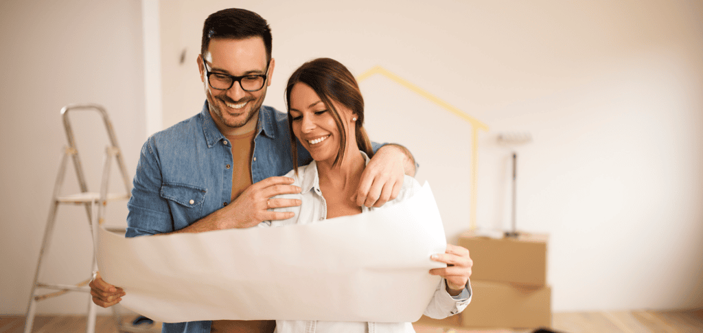 Couple smiling at home renovation plans.