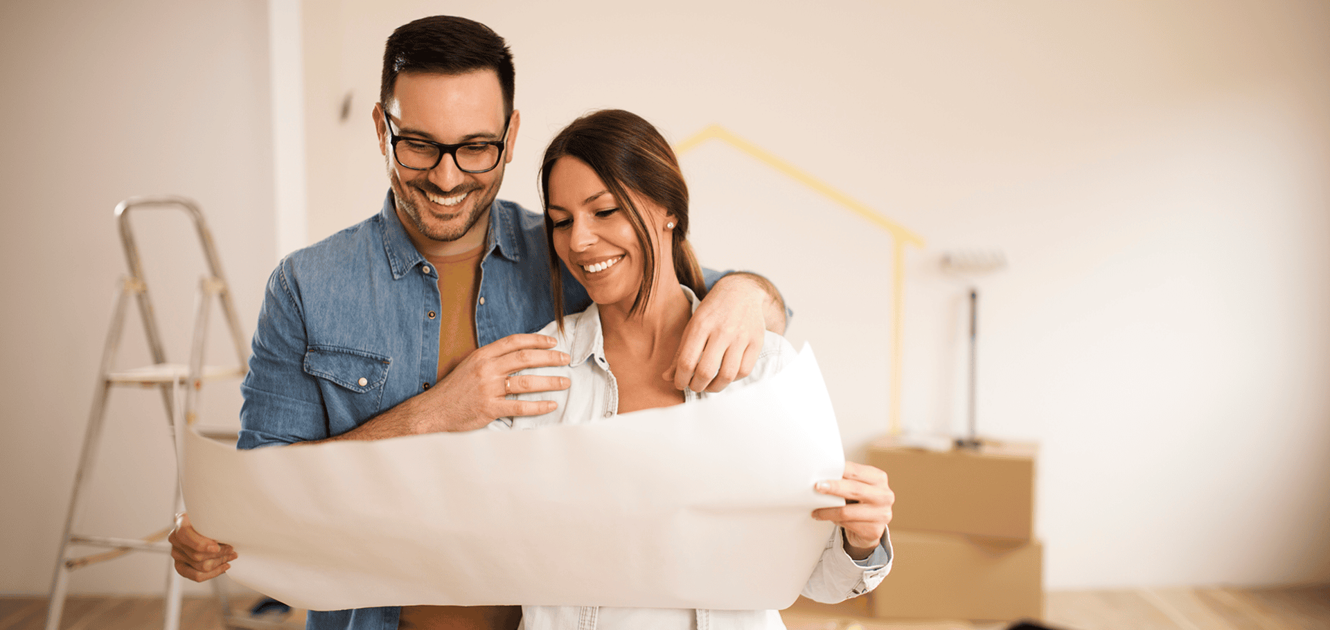 Couple smiling at home renovation plans.