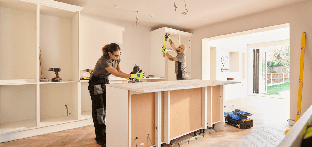 Workers installing cabinets in a kitchen.